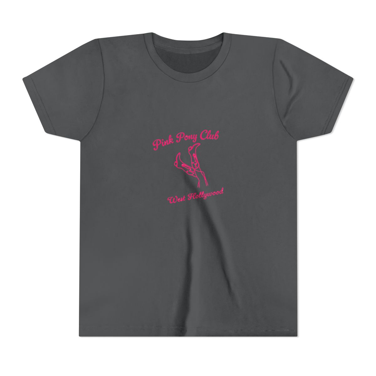 White T Shirt with the text "Pink Pony Club West Hollywood" in pink script. The shirt features a pink line drawing of legs and high heels. The shirt is folded and placed on a light surface (Kids) - alternate angle 5, merchandise
